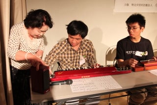 歓迎会で大正琴を教わるアスジャ国費留学生達